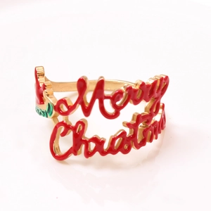 Macro shot of Merry Christmas gold ring with red and green enamel festive details