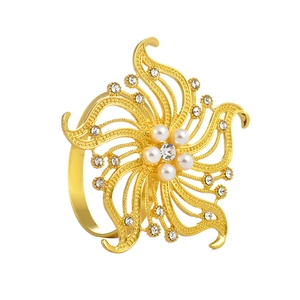 Elegant gold flower napkin ring with white pearls and sparkling crystals on white background