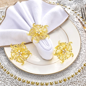 Elegant gold flower napkin ring set with pearls and rhinestones on white tableware