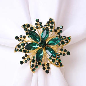 Servilletero de flor dorada con cristales esmeralda para decoración de mesa elegante