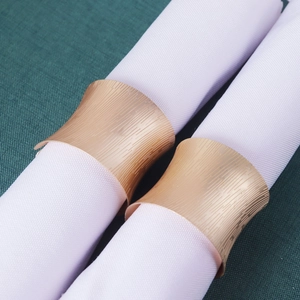 Matte gold napkin rings set with vertical ribbed texture for hotel table setting