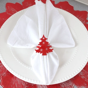 Red Christmas tree napkin ring with snowflake details on a festive table setting