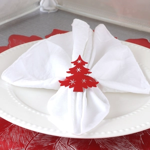 Festive red Christmas tree napkin ring on white plate with elegant holiday table setting