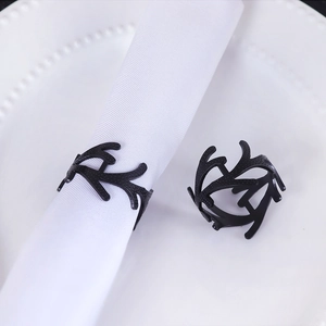 Nordic minimalist matte black coral napkin ring with resin branch design on a white plate