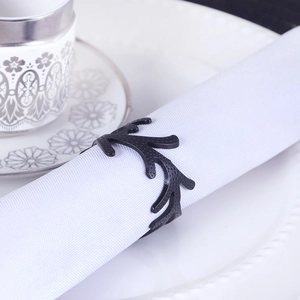Nordic black coral resin napkin ring with textured finish on a white fabric napkin