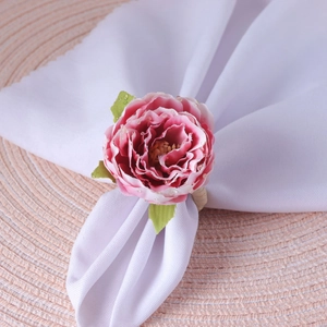 Pink silk rose napkin ring with dewdrop detail on white napkin and woven placemat