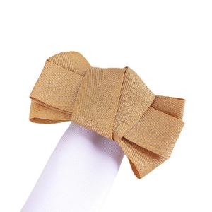 Elegant gold herringbone bow napkin ring with white elastic band on white background