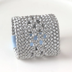 Gros plan d'un rond de serviette en cuir PU tressé gris argenté au motif diamanté