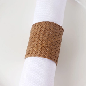 Gros plan d'un rond de serviette en cuir PU tressé marron pour décoration de table