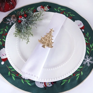 Golden Christmas tree napkin ring with embossed texture on a festive table setting