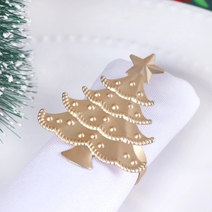 Detail shot of matte gold Christmas tree napkin ring on white fabric table decor