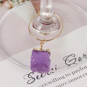 Detail of a natural purple crystal stone charm on a gold-finished wine glass ring marker