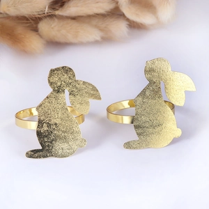 Set of two golden bunny napkin rings for elegant Easter table decor on white background