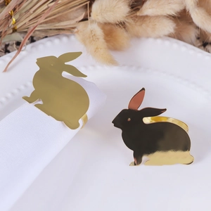 Polished golden rabbit napkin rings for Easter table decor set on white plates
