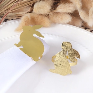 Detailed view of gold bunny napkin rings with glitter finish on a decorative tray