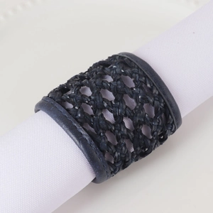 Détail d'un rond de serviette en cuir tressé bleu foncé avec motif texturé