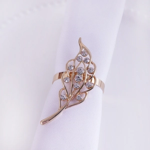 Detailed close-up of a gold hollow leaf napkin ring with sparkling inlaid rhinestones