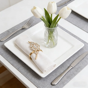 Detail of gold hollow leaf napkin ring with rhinestones on a white napkin setup