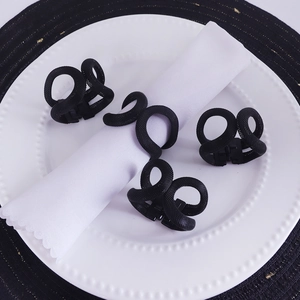 Modern set of four black mesh metal napkin rings in a spiral design for dining decor