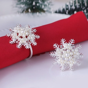 Detailed view of silver snowflake napkin ring with pearls on a red festive napkin