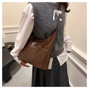 Macro view of brown large-capacity leather tote bag with functional front pocket detail