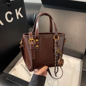 Vintage dark brown bucket bag in glossy finish with gold hardware and top handle strap