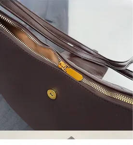 Détail de la fermeture éclair en métal et du fermoir magnétique sur sac en cuir marron