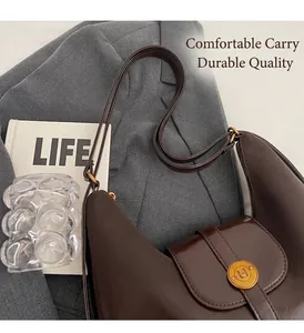 Vue détaillée du sac demi-lune en cuir marron avec bandoulière réglable et boucle dorée