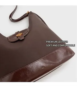 Détail du sac hobo marron foncé montrant les textures de cuir mat et brillant avec fermoir doré