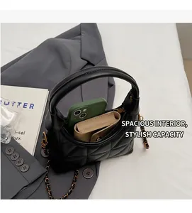 Détail de l'intérieur spacieux d'un sac en cuir noir matelassé avec bandoulière chaîne