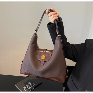 Détail du sac à bandoulière marron vintage avec boucle dorée et texture cuir mat