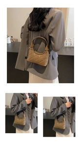 Détail d'un sac à main en cuir taupe matelassé avec bandoulière chaîne dorée sur mannequin