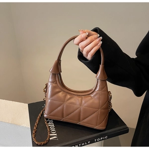 Détail du sac à main matelassé marron avec chaîne dorée et forme de lune élégante