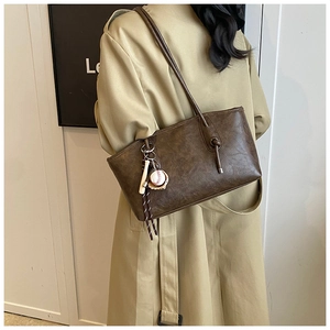 Detail view of large dark brown tote bag with vintage texture and baseball charm