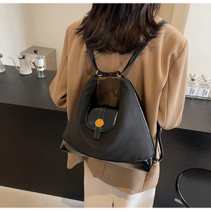 Détail du grand sac cabas noir avec boucle en métal doré porté par un mannequin femme