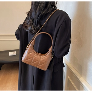 Détail d'un sac à main en cuir matelassé marron avec motifs triangles et bandoulière dorée
