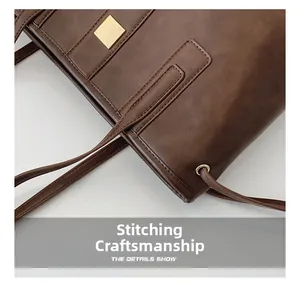 Detail showing high-quality stitching and square gold metal accent on brown leather tote bag