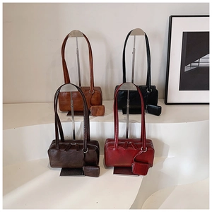Detail view of retro pillow bags in brown, black, coffee and wine red with side pouches