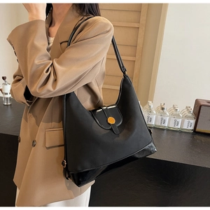 Détail du sac cabas noir avec nylon mat et coutures en cuir brillant et boucle dorée
