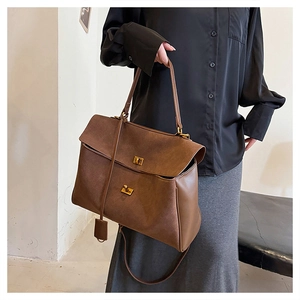 Detailed view of caramel suede tote bag with metal square buckle and leather handle