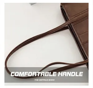 Detail showing the comfortable handle and stitching on this brown faux leather tote bag