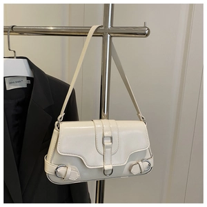 Detail van crème baguette tas van glanzend leer met zilveren metalen gesp aan een rek