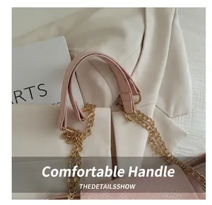 Detail of pink snake-embossed tote bag featuring golden metal rings and double chain strap
