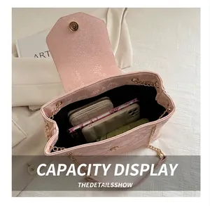 Internal view of pink snakeskin shoulder bag showing its capacity for daily items