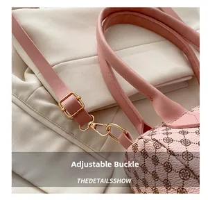 Detail of pink vintage printed handbag showing adjustable gold buckle and shoulder strap
