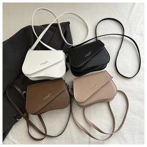 Flat lay of four colorful saddle bags in white, black, coffee and beige synthetic leather