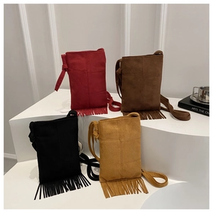 Détail de quatre sacs à franges en daim colorés montrant la texture des coutures