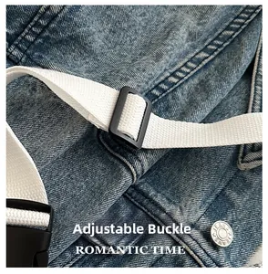 Détail du sac bandoulière en denim bleu avec sangle blanche et boucle noire