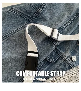 Détail de la sangle blanche réglable avec boucle noire sur sac en jean délavé