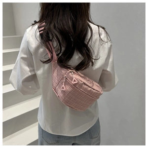 Vue arrière d'un sac banane à carreaux roses porté en bandoulière sur fond blanc épuré